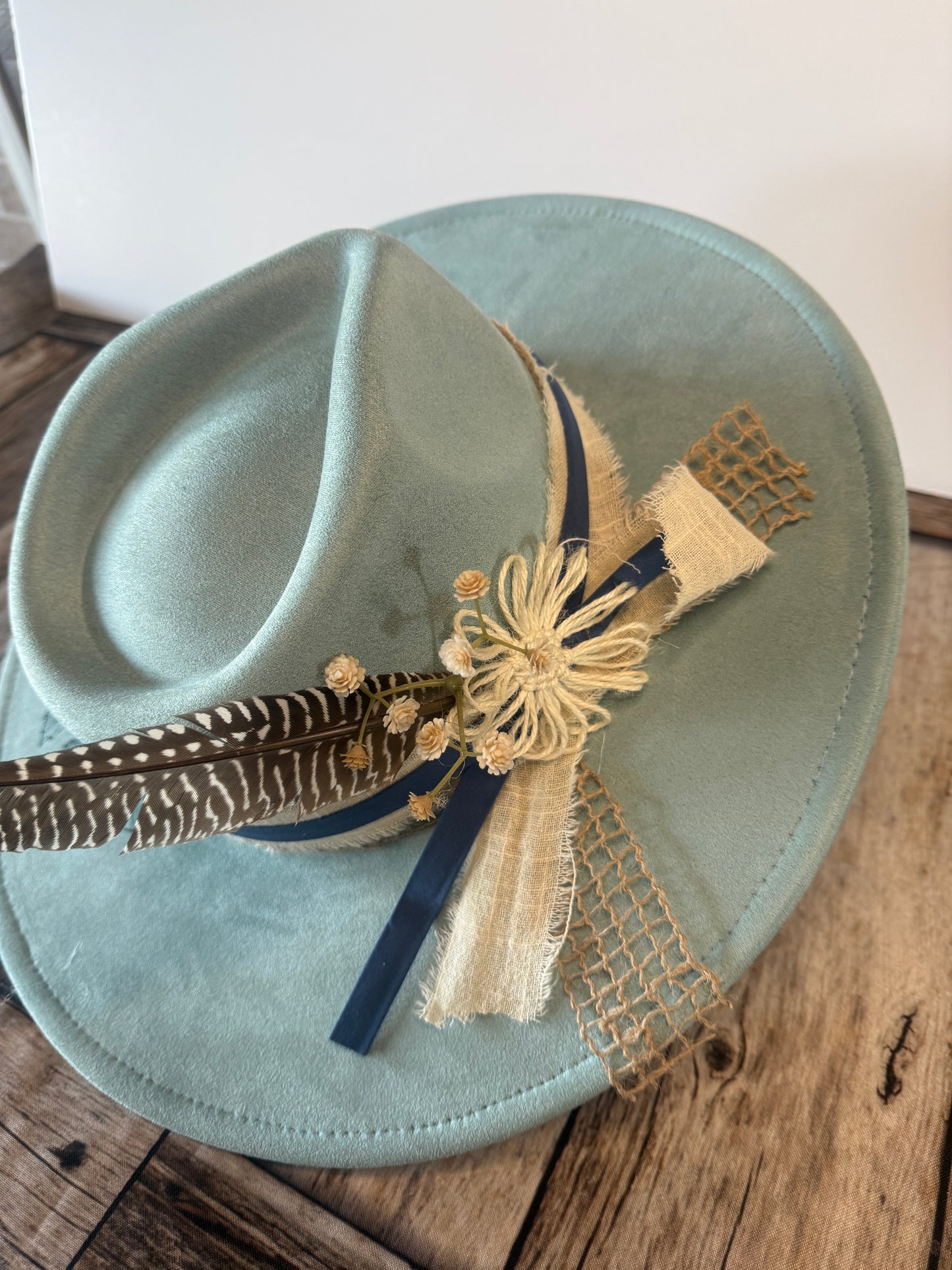Burned flowers on blue hat with fancy band